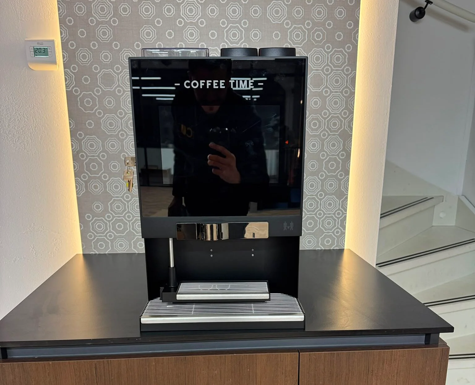 Koffiemachine van CO Koffie bij De Haagse Beveiliging, met bekers met eigen DHB logo